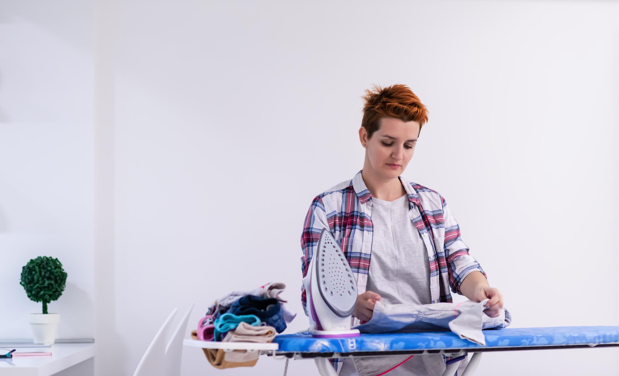 Artisan at work with modern embroidery machine and laptop